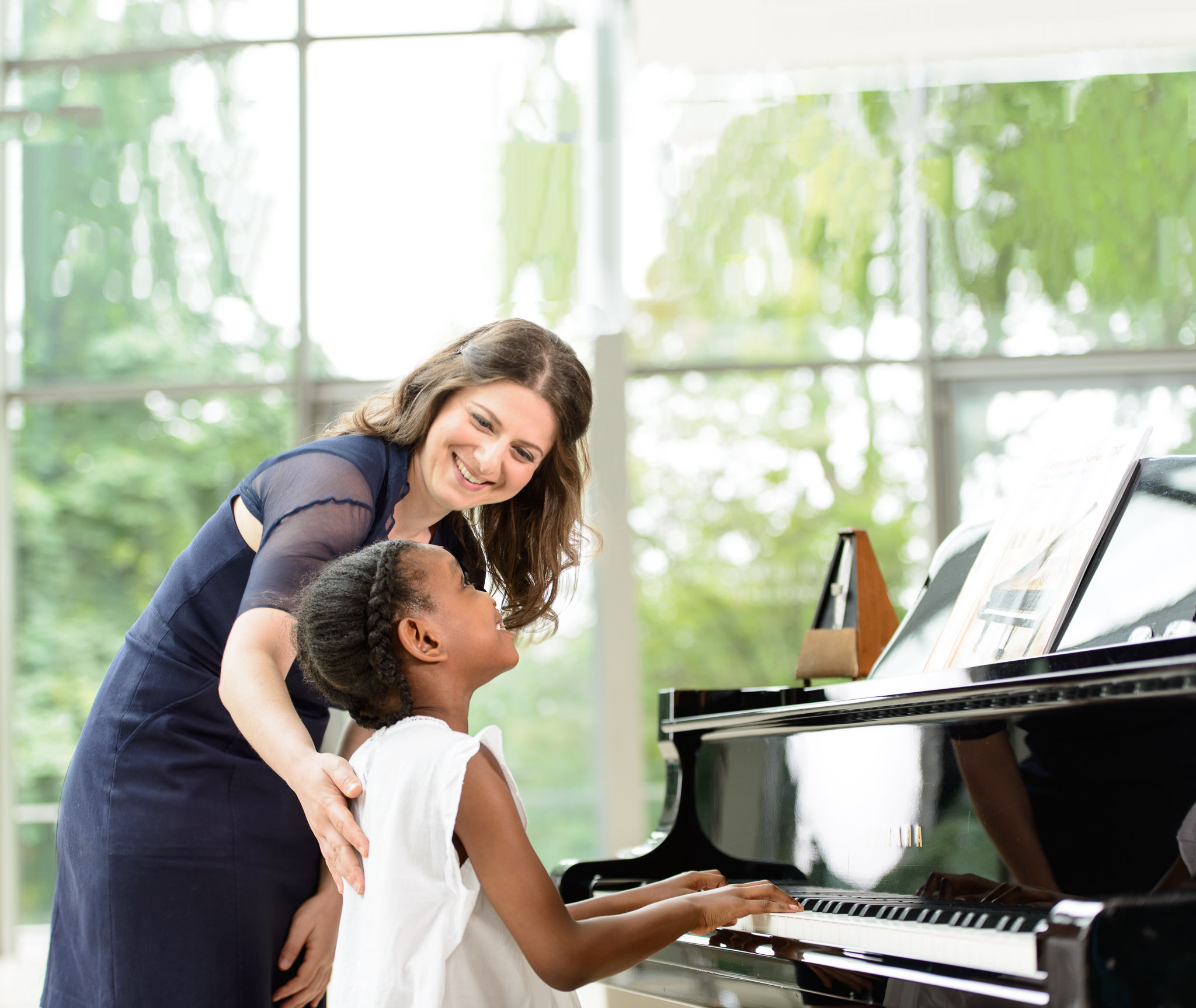 Teacher showing a student how to play a piano