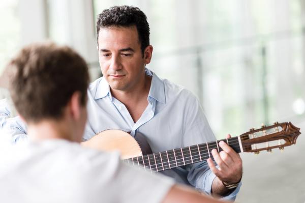Become an RCM Certified Teacher - teacher with guitar