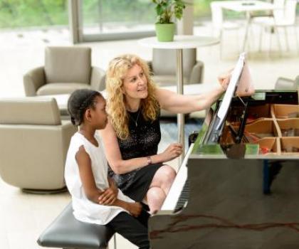 woman teaching young student at piano