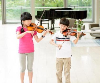 two violin students perform a duet
